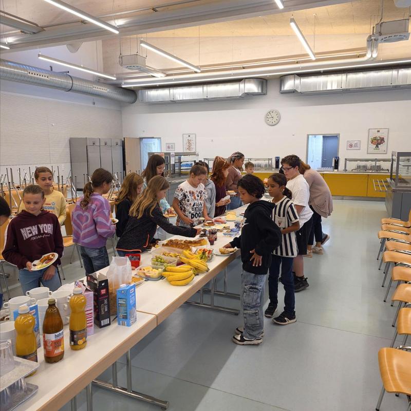 Schüler:innen an einem Frühstücksbuffet