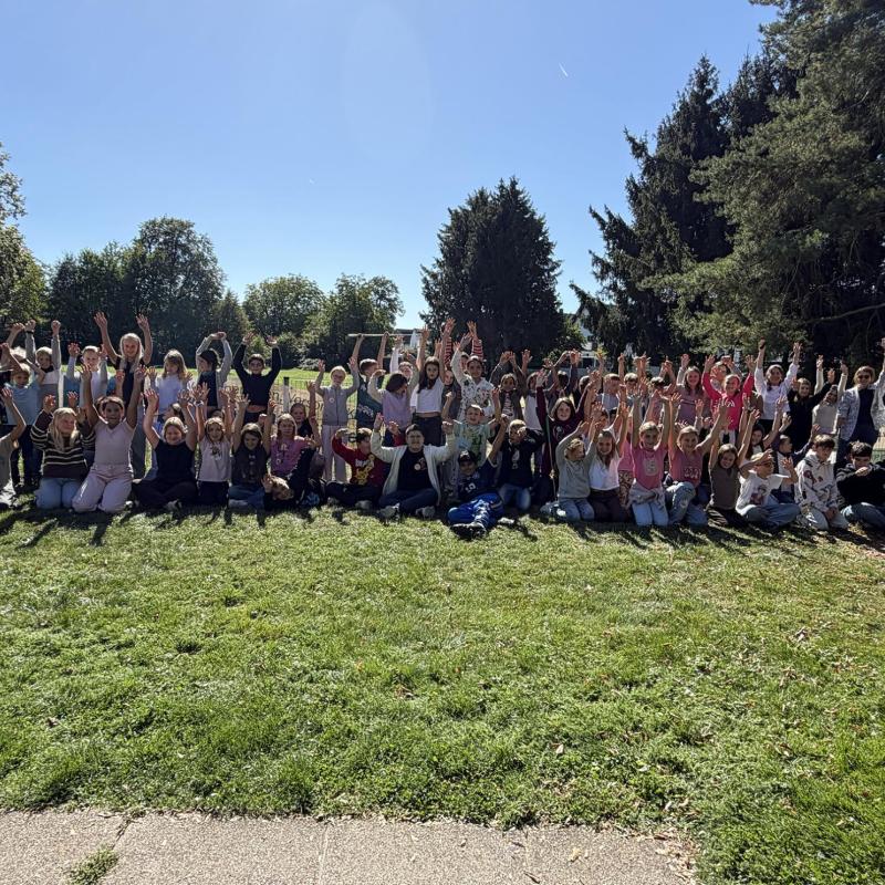 Foto der neuen 5er auf einer Wiese mit Bäumen im Hintergrund, fast alle strecken die Hände hoch